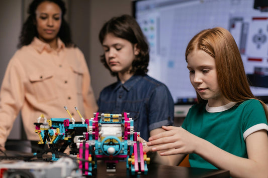 Teacher and two students building a robotics project in a STEAM class