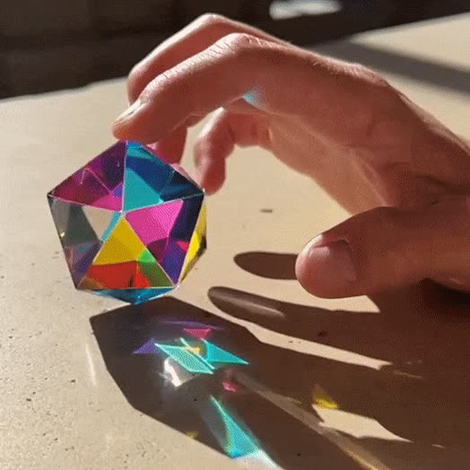 Animated view of The Motus icosahedron rotating, its twenty translucent faces mixing colour
